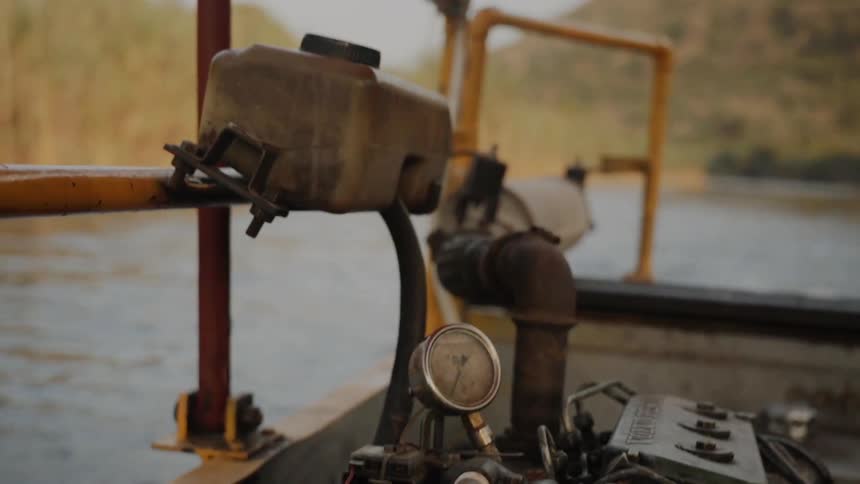 A boat with its engine traveling on a river