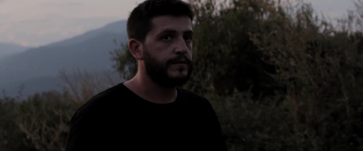 A man walks on a trail looking up and around anxiously