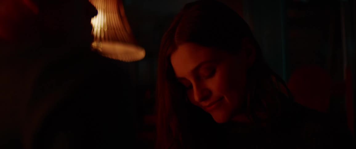 A woman and man sitting opposite each in a dimly lit room