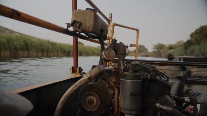 A boat with its engine traveling on a river