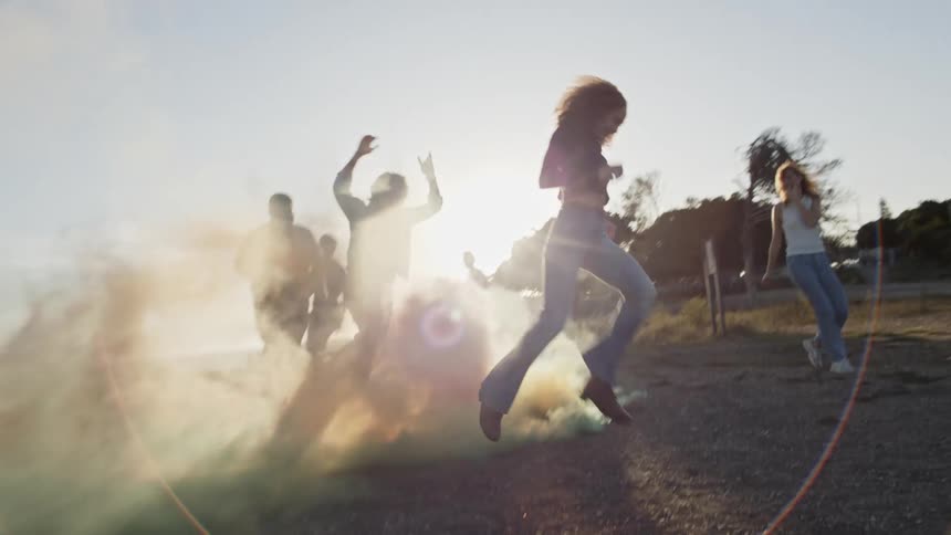 People running around jumping over colored smoke bombs