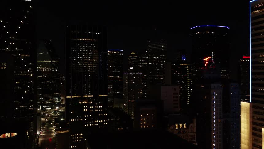 The lights along rooftops and windows of city skyscrapers glow and shine at night