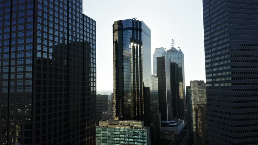 Skyscraper windows and facades reflect the city around them