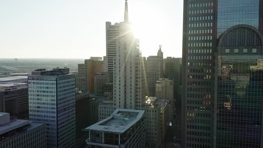 The sun shining between skyscrapers in a large metropolis