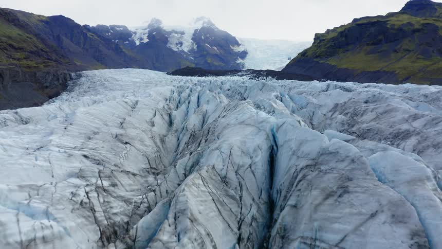 Jagged ridges of ice with mountains and slope behind