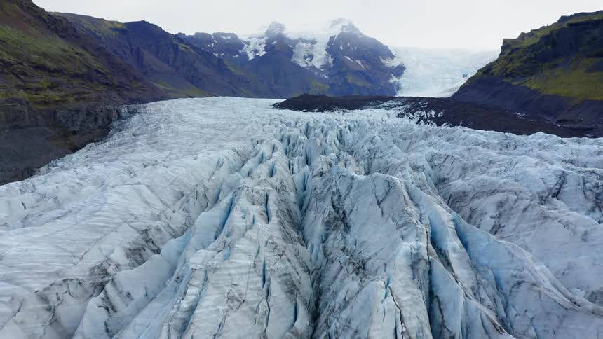 Aerial view of massive glacier surrounded by mountains