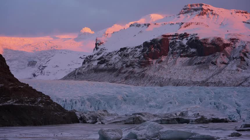 A glacier with a mounting covered in snow in the background