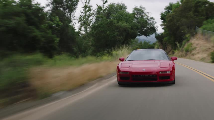 Red ferrari driving on rural two lane highway