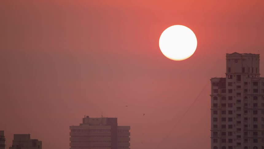 The sun over a skyscraper in the city