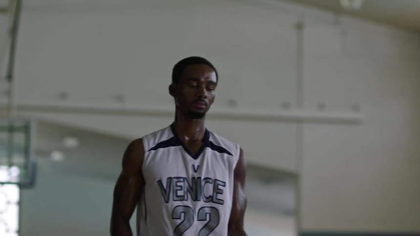 A man in a gym shooting a basketball
