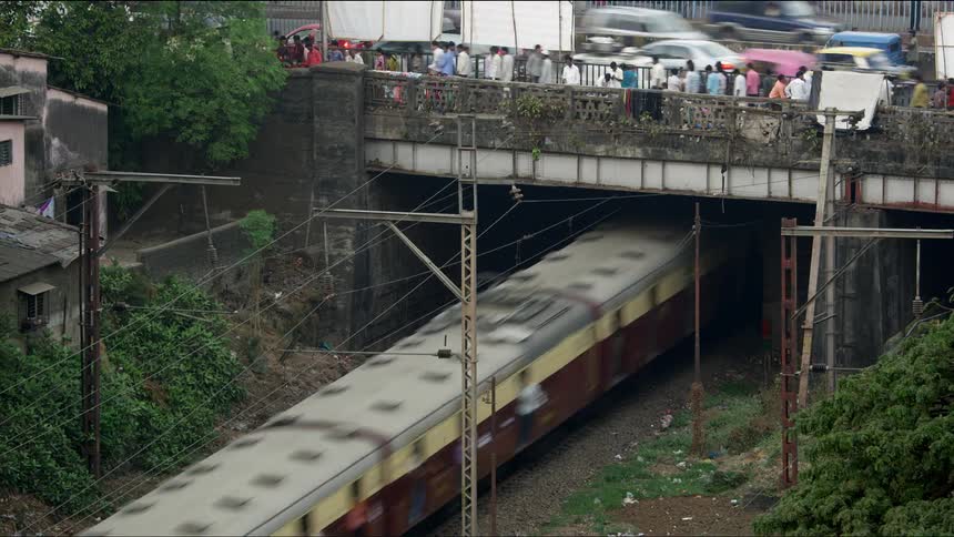 People and cars on an overpass above a train