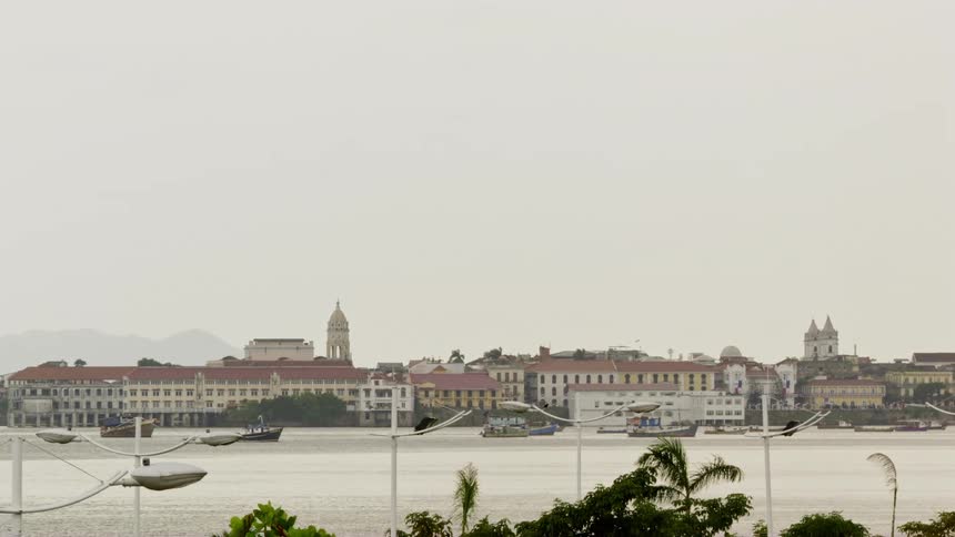 A river with boats with buildings and the sky in the background
