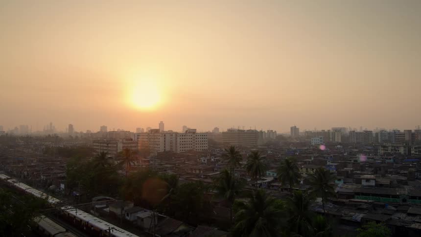 Sun rises over hazy city neighborhoods