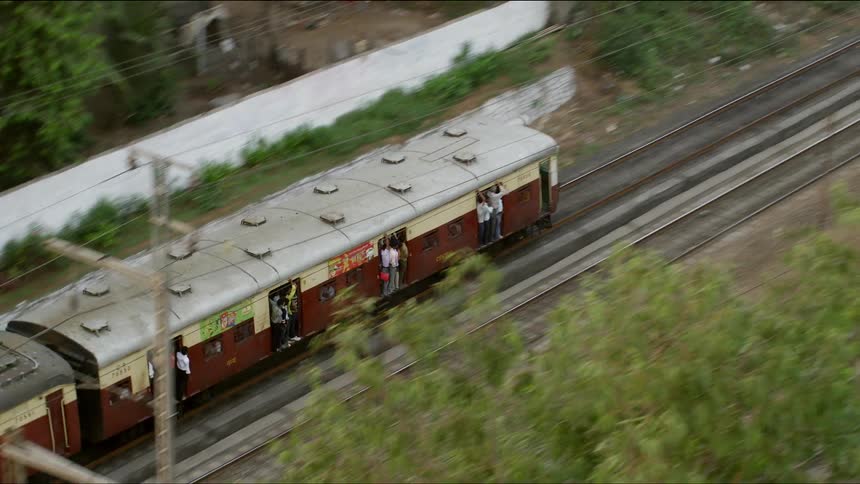 An aerial view of a passenger train traveling in a city