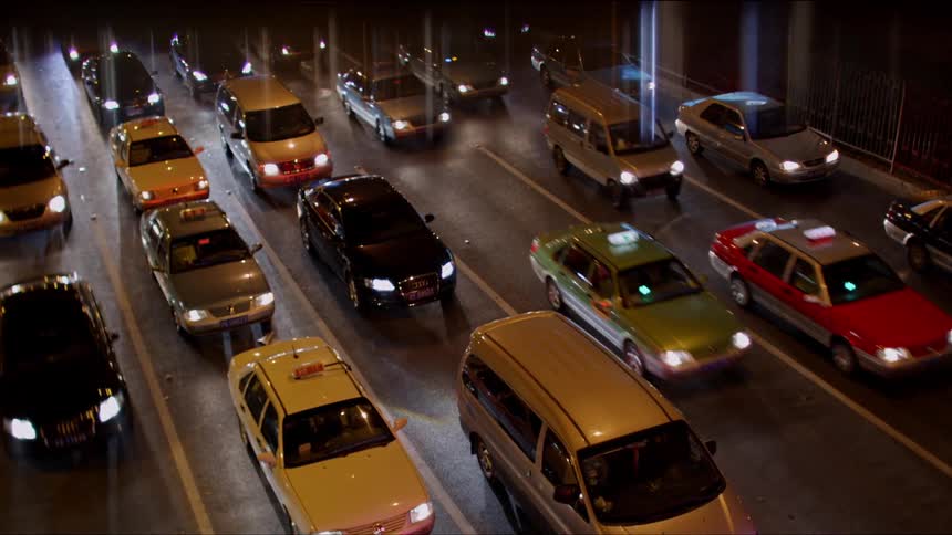 Traffic moves slowly on a multi lane highway with some vehicles completely stopped
