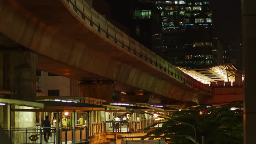 People walk in a busy city building at night