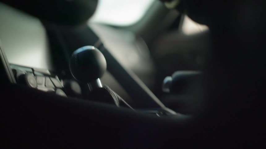 A person shifts their car as they race