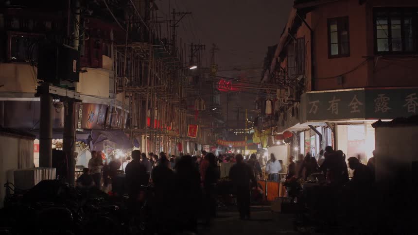 Large crowds flood an asian neighborhood in a city