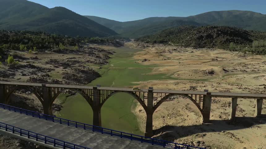 Two bridges span a shallow river running through a valley