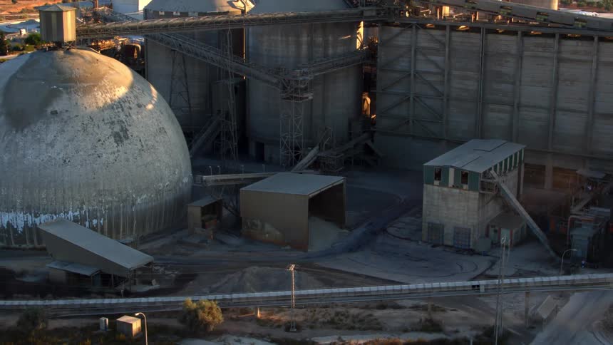 Buildings and silos sit under a sunny sky