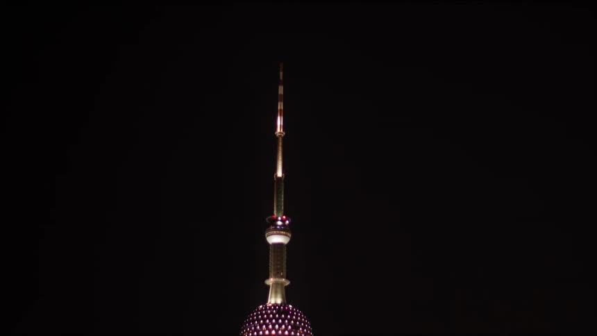 A tall urban spire lit up at night