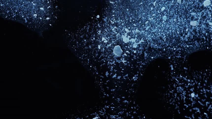 Flour sprinkled and clumped across a black table top
