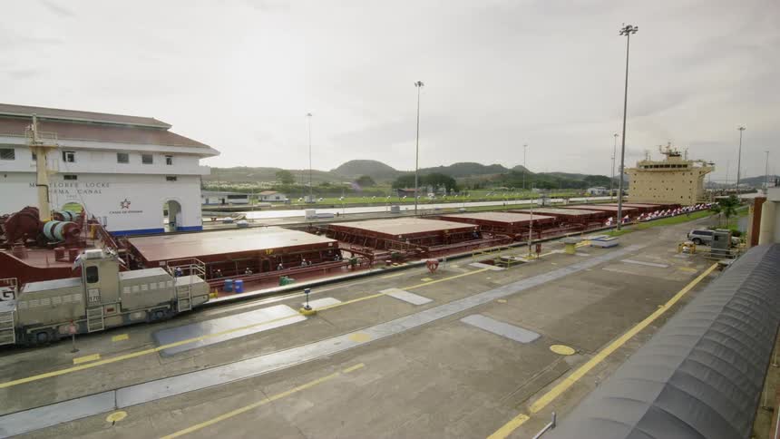 A cargo ship is pulled through the panama canal