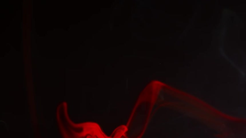 Red liquid slides down in front of a black background