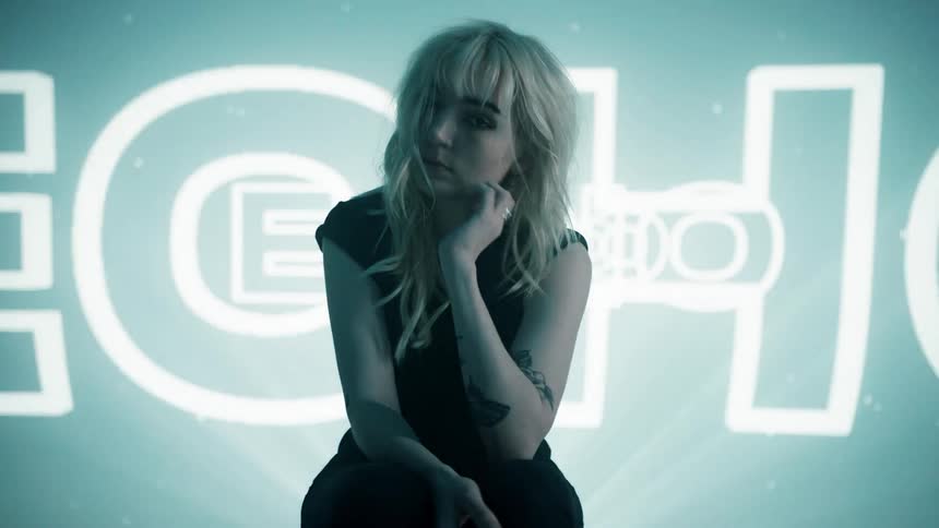 Young woman poses for camera in front of projected text on backdrop