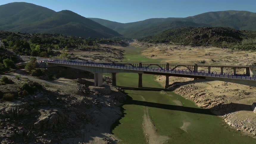 Cars drive across a bridge over a river