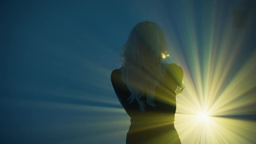 A blonde white woman walks into a bright light