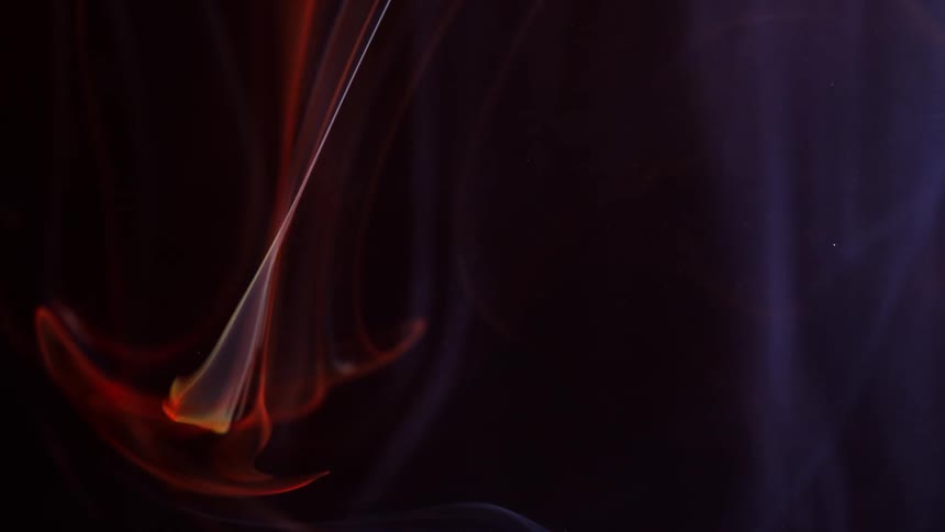 Red blue and yellow smoke swirls against black background
