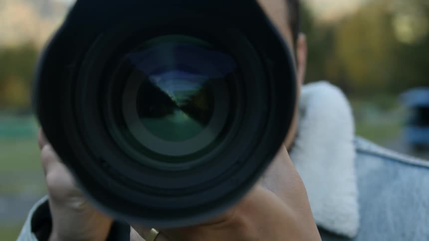 Man holds a camera with a long lens in preparation of taking a photo