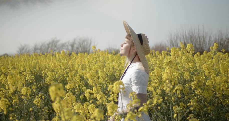 A woman outside surrounded by flowers