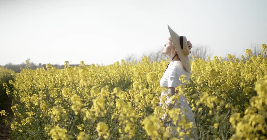 A woman stands in a field of flowers