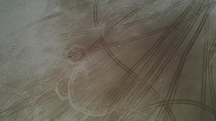 Tracks and circles mark the snow dusted brown surface of flat lands
