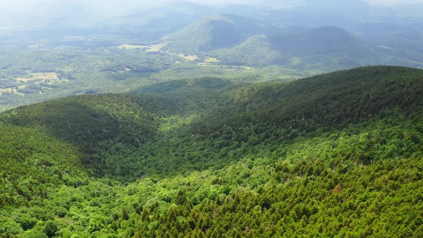 Haze covers forested hills in the distance
