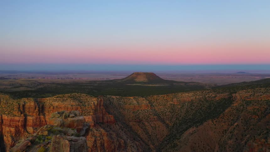 A large canyon with a hill in the distance
