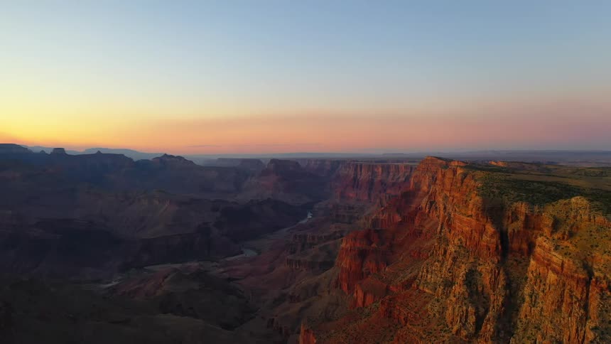 A rocky canyon with sunlight shining and glowing at sunrise