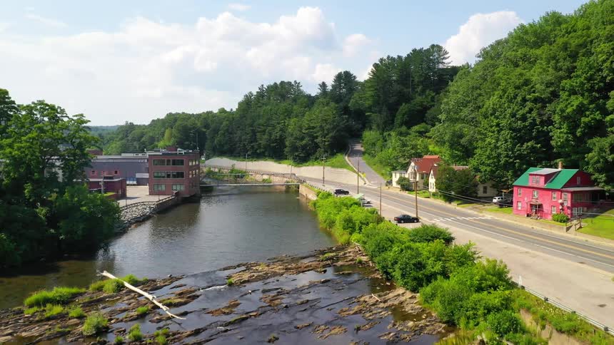 A road next to a river with houses trees and buildings