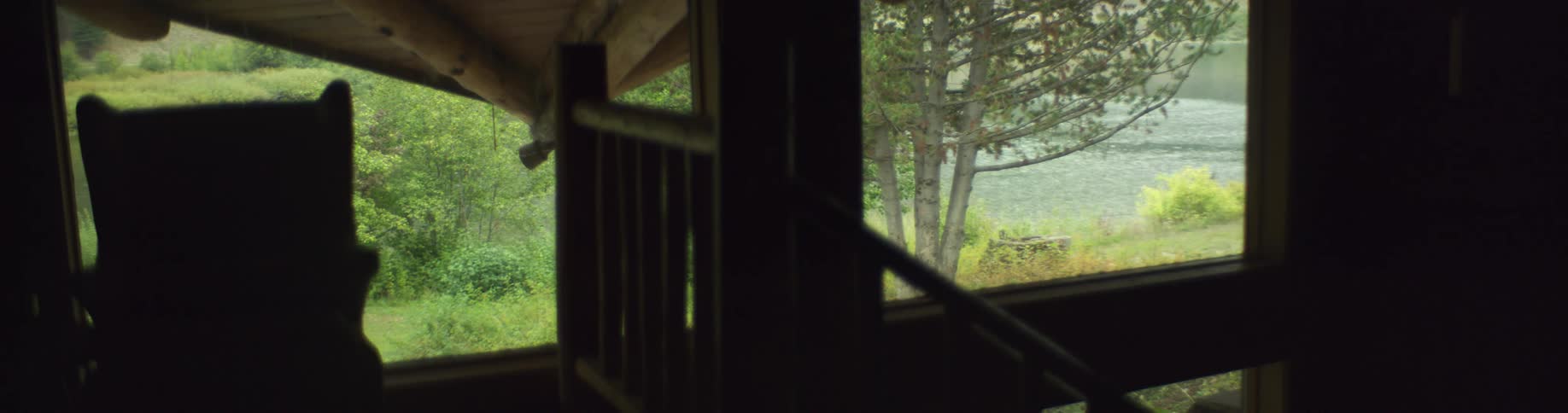 A person walks through the dimly lit room of a building near a river