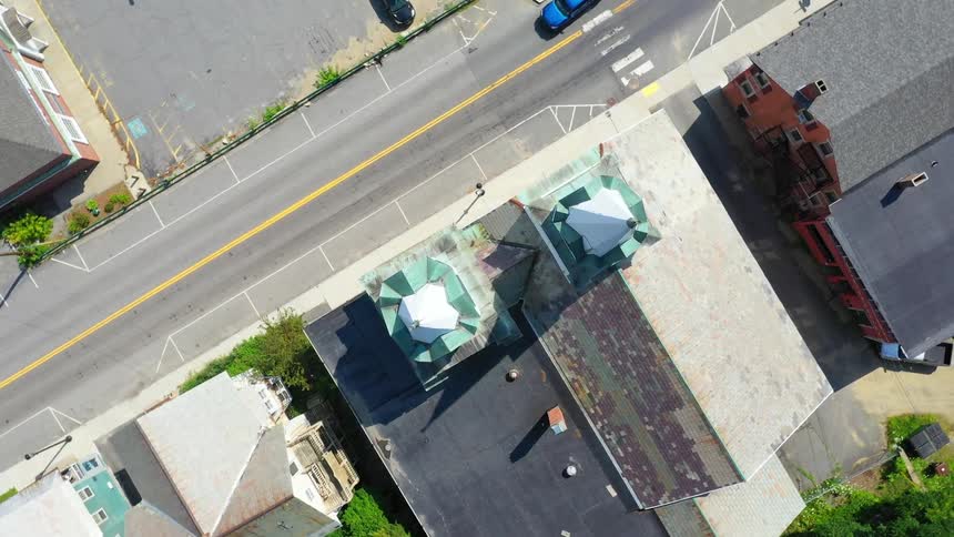 Aerial footage of blue truck driving down neighborhood street