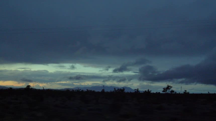 A car travels on a remote road at sunset
