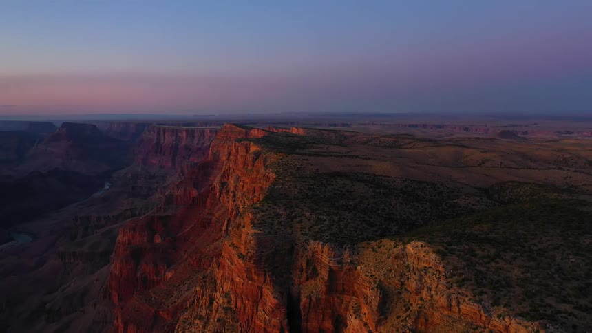 The sun rests on the side of the canyon