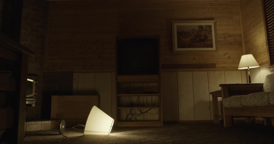 An empty living room with a lamp lying on the floor