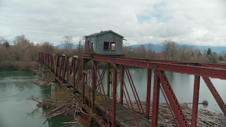 Old bridge spans the calm lake under a cloudy sky
