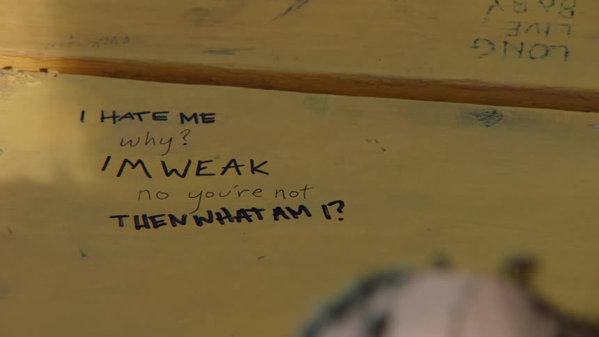 Someone prints text on a whiteboard with a marker