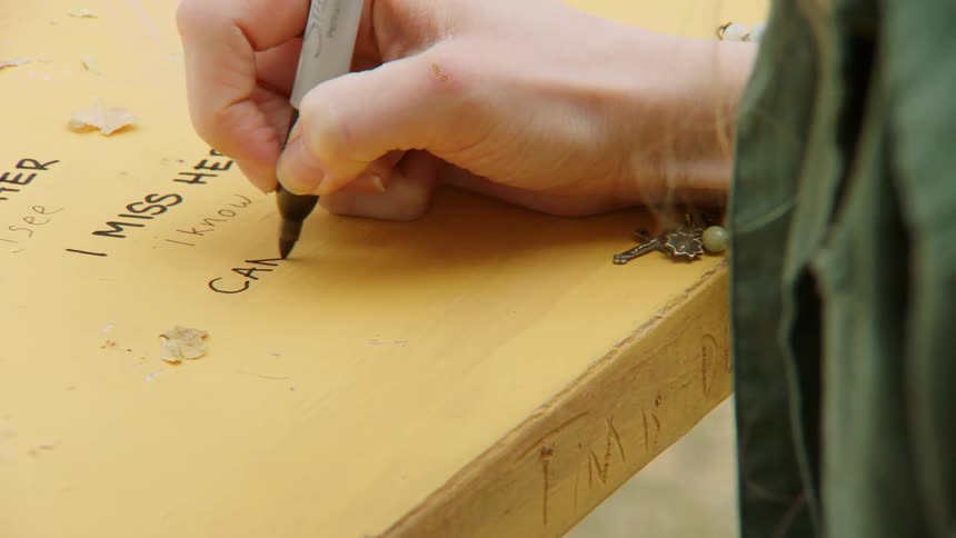 Woman writes on desk surface with a marker