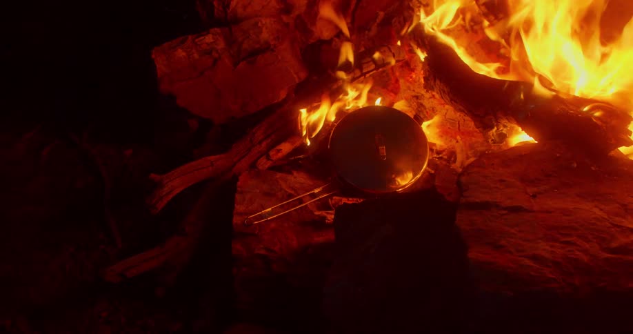 Skillet heating on rock near a camp fire