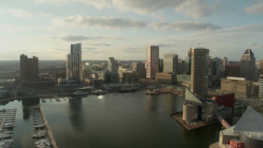 A port with boats sits on a coastline of a large downtown urban area